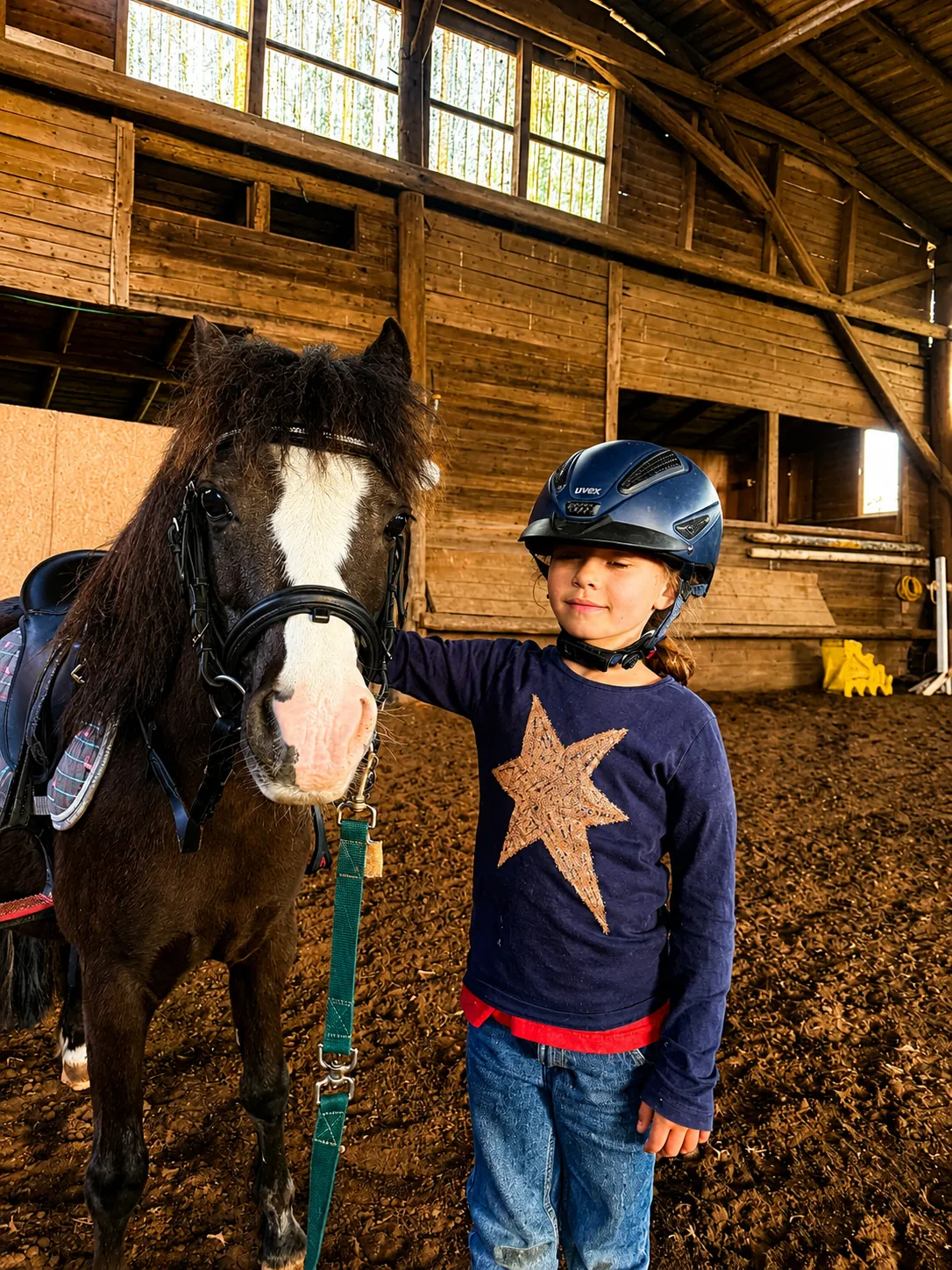 Kind mit Pony in der Ponyreitschule